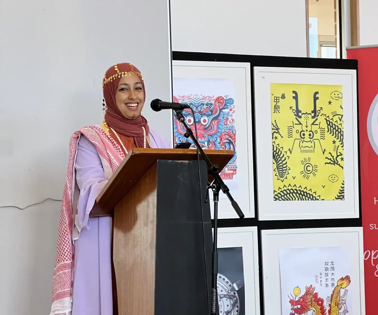 Woman in colourful attire speaks at podium.