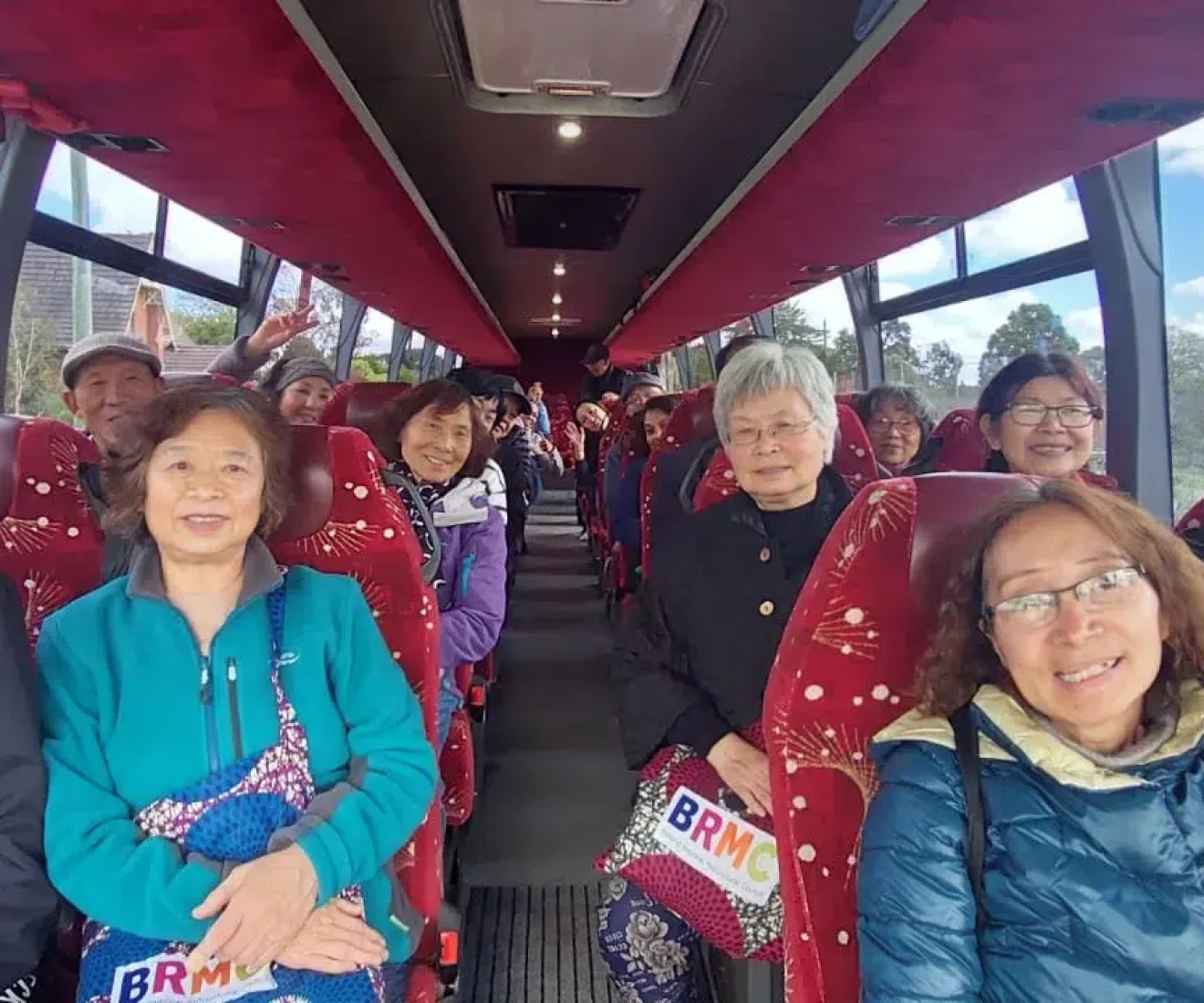 Group of happy seniors on a bus trip.