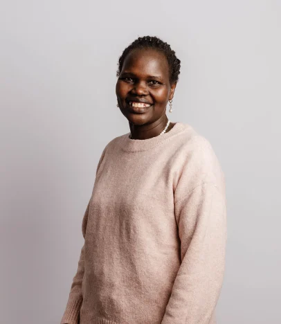Smiling person wearing a pink jumper.