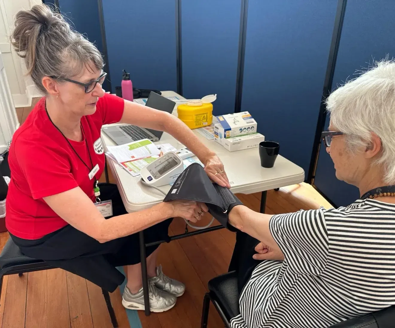 Healthcare worker taking patient's blood pressure.