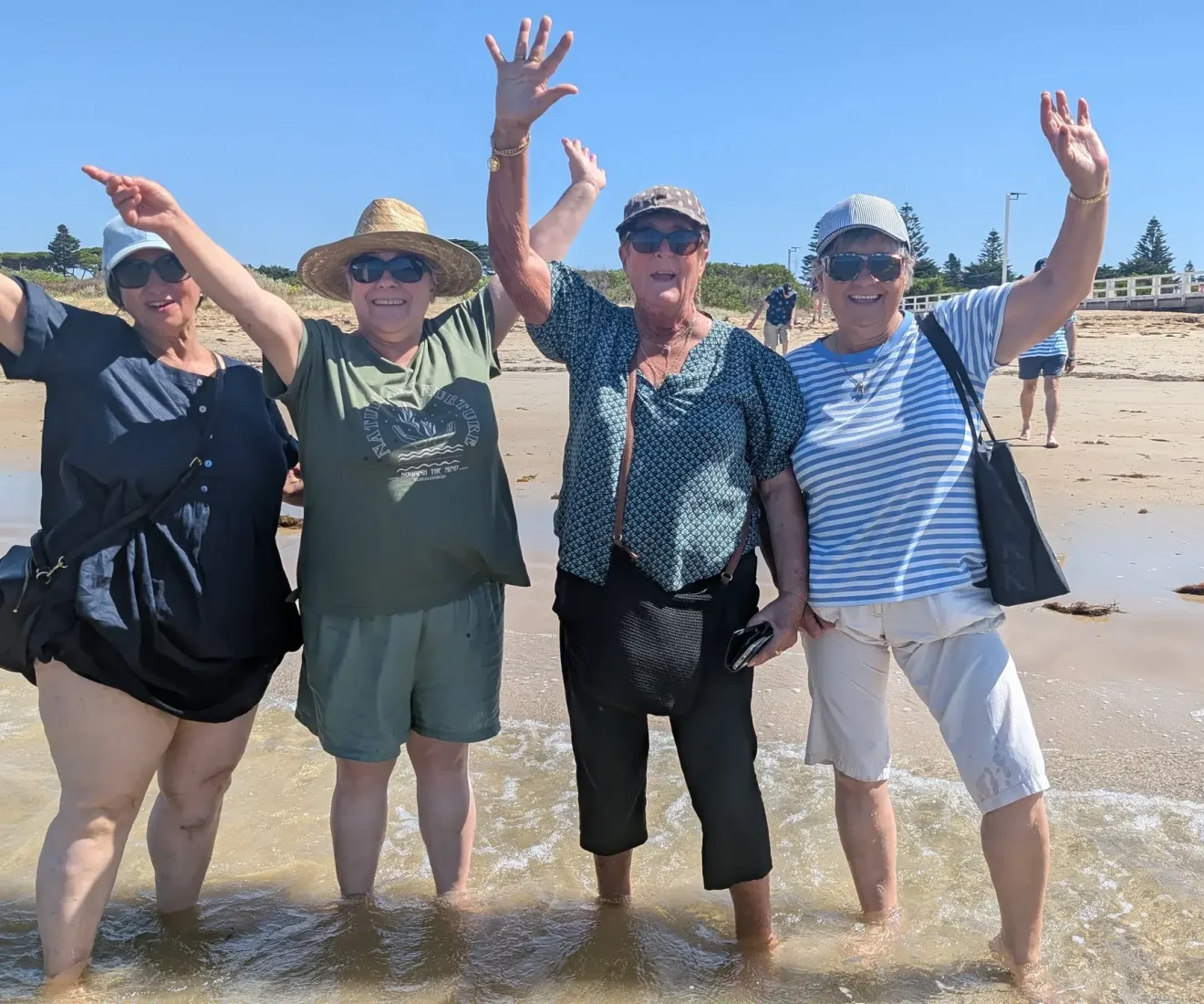 Four friends smiling on sunny beach